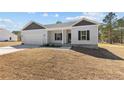 Charming single-story home featuring a gray exterior, attached garage, and well-manicured lawn at 4983 Ray Rd, Spring Lake, NC 28390