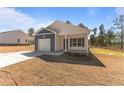Lovely single-story home with gray and white exterior, a covered porch, and an attached garage at 5011 Ray Rd, Spring Lake, NC 28390