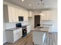 Modern kitchen with white cabinets, granite countertops, and stainless steel appliances at 161 Jones Creek Ln, Lillington, NC 27546