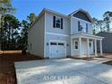 Charming two-story home featuring gray siding, black shutters, white trim and a single-car garage with a concrete driveway at 187 Regis Ln, Coats, NC 27521