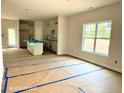 Open-concept living room featuring a view of the kitchen, and large windows providing ample natural light at 187 Regis Ln, Coats, NC 27521