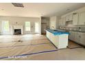 Open-concept living room featuring a fireplace, view of the kitchen and back yard via large glass patio doors at 187 Regis Ln, Coats, NC 27521