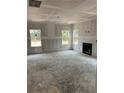 Bright, unfinished living room with large windows and a cozy fireplace, ready for customization at 268 Dove Rd, Harnett County, NC 28326