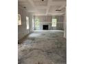Large unfinished living room featuring multiple windows and a cozy fireplace, ready to be personalized at 268 Dove Rd, Harnett County, NC 28326