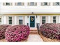 Close-up of front door with colorful wreath and brick pathway lined with shrubs at 1312 Gormly Cir, Sanford, NC 27330