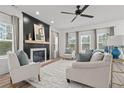 Bright living room with a modern fireplace, neutral decor, and large windows at 496 Persimmon Tree Dr, Cameron, NC 28326