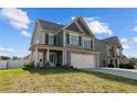 Charming two-story home features a two-car garage, covered porch, and well-maintained lawn at 91 Bicentennial Way, Cameron, NC 28326