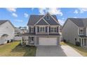 Charming two-story home features a two-car garage, covered porch, and manicured front yard at 91 Bicentennial Way, Cameron, NC 28326