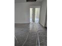 Unfurnished bedroom featuring neutral carpet covered in plastic, white walls, and visible windows from the doorway at 106 Driftwood Ct, Sanford, NC 27330