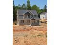 Two-story home featuring gray shutters, vinyl siding, and a covered front porch set within an unfinished yard at 106 Driftwood Ct, Sanford, NC 27330