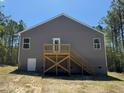 Back of home with wood deck and stairs, gray siding, and two windows with white trim at 182 Horse Trot Ln, Sanford, NC 27332