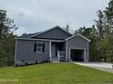 Attractive single-story home showcasing gray siding, a welcoming entrance, and an attached one-car garage at 182 Horse Trot Ln, Sanford, NC 27332