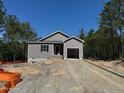 New construction with gray siding, a dark shingled roof, a large lot, and an attached two-car garage at 182 Horse Trot Ln, Sanford, NC 27332