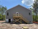 Rear view of the property showing the unfinished yard with a stairway leading to the door at 182 Horse Trot Ln, Sanford, NC 27332