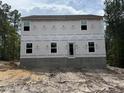 Rear view of unfinished two-story home, showcasing the house wrap and foundation at 204 Horse Trot Ln, Sanford, NC 27332
