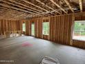 Unfinished living room with exposed wooden framing, concrete floors and natural light at 204 Horse Trot Ln, Sanford, NC 27332