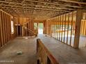 View of an unfinished interior with exposed wood frame walls, concrete flooring, and staircase under construction at 28 Horse Trot Ln, Sanford, NC 27332