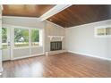 Bright living room with hardwood floors, brick fireplace, and large windows offering ample natural light at 107 Pandora Cir, Erwin, NC 28339