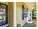 Covered front porch featuring neutral siding, purple shutters, and trim, offering a shaded and inviting entryway at 45 Ridgecrest Rd, Cameron, NC 28326