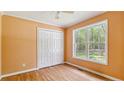 Bright bedroom with hardwood floors, closet, a large window showcasing a view of the outdoor greenery at 5122 Pheasant Ln, Sanford, NC 27332
