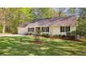 Well-maintained ranch home with an attached garage, front yard, and mature trees providing shade and privacy at 5122 Pheasant Ln, Sanford, NC 27332
