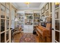 Cozy home office with a wall of built-in bookshelves, a desk, hardwood floors, and a piano at 85 Heatherspring Way, Spring Lake, NC 28390