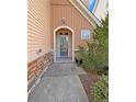 Close-up of the front door showcasing stonework and fresh landscaping around the arched entry at 94 Red Coat Dr, Cameron, NC 28326