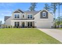 Well-maintained two-story home with a covered porch, two-car garage, and a lush green lawn at 354 Timber Skip Dr, Spring Lake, NC 28390