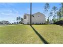 Exterior view of a well-maintained home with a large lawn, two-car garage, and well manicured landscaping at 354 Timber Skip Dr, Spring Lake, NC 28390