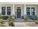 Inviting front entrance with a blue door, decorative wreath, and charming stone pillar accents at 354 Timber Skip Dr, Spring Lake, NC 28390