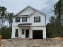 New home with white siding, black shutters, covered entryway, and an attached two-car garage at 142 Horse Trot Ln, Sanford, NC 27332