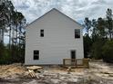 Rear view of a newly constructed home featuring white siding and a small wooden deck at 142 Horse Trot Ln, Sanford, NC 27332