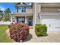 Charming two-story home with manicured landscaping, blue shutters, a two-car garage, and a welcoming front porch at 148 Huzzas Cir, Cameron, NC 28326