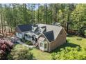 Aerial view of a brick home with an attached garage surrounded by mature trees and lush landscaping at 8042 Royal Dr, Sanford, NC 27332