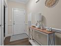 Inviting entryway featuring a console table with modern decor and a stylish rug on wood flooring at 291 Gallery Dr # 102, Spring Lake, NC 28390
