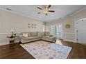 Bright living room with an L-shaped sofa, area rug, ceiling fan, and sliding doors to a balcony at 291 Gallery Dr # 102, Spring Lake, NC 28390
