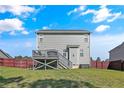 The back of the house showcases a wooden deck, and a large yard enclosed by a rustic wooden fence at 254 Angel Oak Dr, Bunnlevel, NC 28323