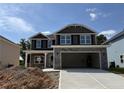 New construction home boasts a stone-accented facade, covered porch, and an oversized two-car garage at 111 Southern Estates Dr, Sanford, NC 27330
