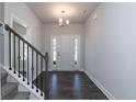 Inviting foyer featuring hardwood floors, a stairway with metal balusters, and natural light from the front door at 119 Southern Estates Dr, Sanford, NC 27330