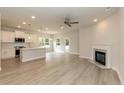Open floor plan with fireplace, kitchen island, white cabinets, stainless appliances, and recessed lights at 214 Drayton Hall Ln, Sanford, NC 27330