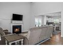 Inviting living room with a fireplace, hardwood floors, and open layout leading to the kitchen at 55 Bow Common Way, Cameron, NC 28326