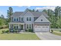 Attractive two-story home showcasing a covered front porch and an attached two-car garage at 99 Wildlife Bridge Ct, Spring Lake, NC 28390