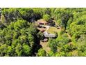 Aerial view of property featuring wooded acreage, home, and detached garage/storage building at 1409 Dogwood Acres Dr, Sanford, NC 27330