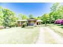Exterior shot of home featuring a brick facade, covered porch, and well-maintained lawn at 1409 Dogwood Acres Dr, Sanford, NC 27330