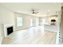 Bright, open-concept living room featuring a fireplace, hardwood floors, and access to the kitchen at 156 Southern Estates Dr, Sanford, NC 27330