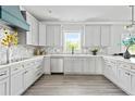 Modern kitchen featuring white cabinets, stainless steel appliances, and light wood flooring at 65 Alder Dr, Cameron, NC 28326