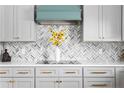 A detailed view of the kitchen with a tiled backsplash and white cabinets at 65 Alder Dr, Cameron, NC 28326