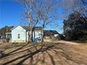 Spacious backyard featuring the home's exterior, screened porch, and mature trees at 713 E Divine St, Dunn, NC 28334