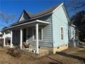 Side view of the home featuring a covered porch, blue exterior, and landscaping at 713 E Divine St, Dunn, NC 28334