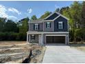 Charming two-story home featuring gray and navy blue siding with a spacious two car garage at 136 Baneberry Pl, Broadway, NC 27505
